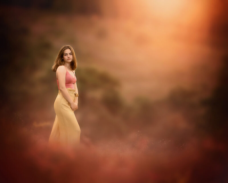 Canon-EOS-R-fine-art-portret-van-een-jonge-vrouw-op-de-heide-tijdens-ondergaande-zon-in-de-magie-van-het-licht-door-natuurlijk-licht-fotograaf-Willie-Kers-uit-Apeldoorn