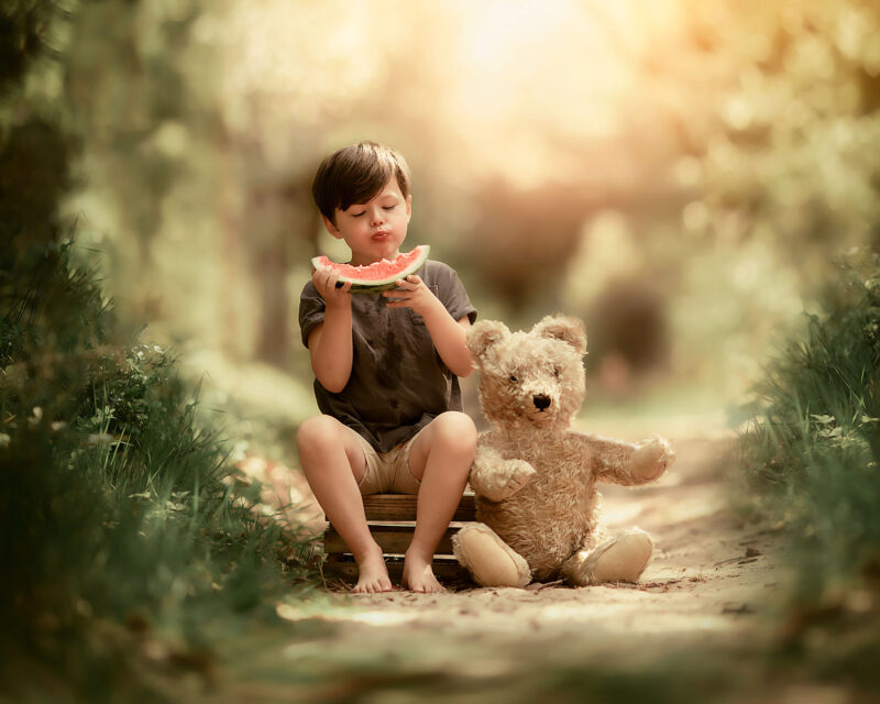 Canon-Fine-art-spring-portrait-of-a-young-boy-eating-a-water-melon-in-the-forest-by-Dutch-photographer-Willie-Kers